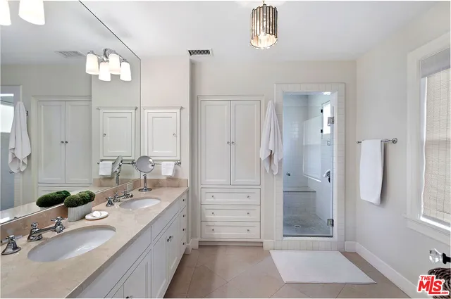 a spacious bathroom with a granite countertop sink a mirror a vanity and a shower
