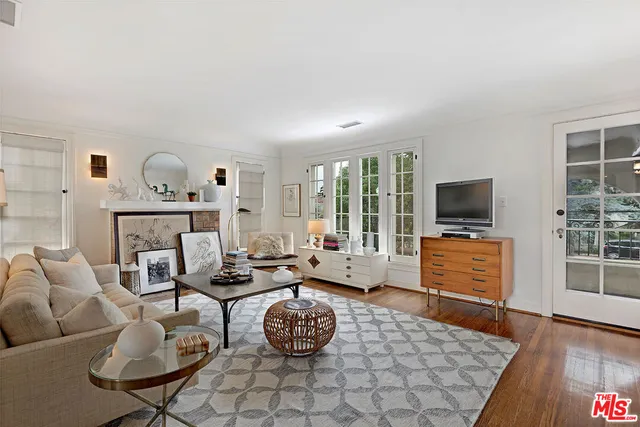 a living room with furniture a flat screen tv and a floor to ceiling window