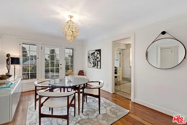 a dining room with furniture a rug and a mirror