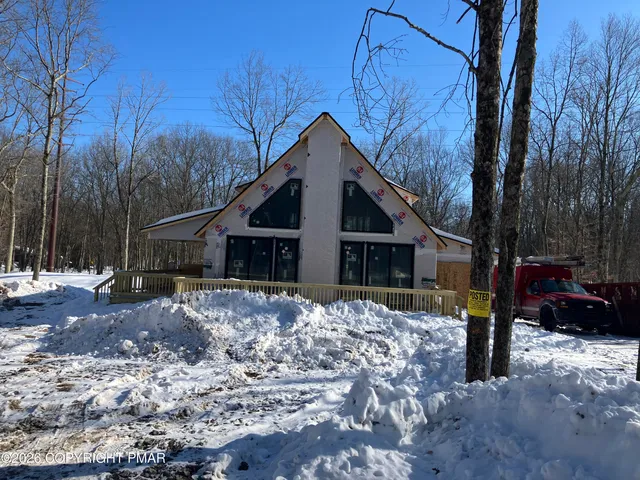a front view of a house with a yard covered in snow