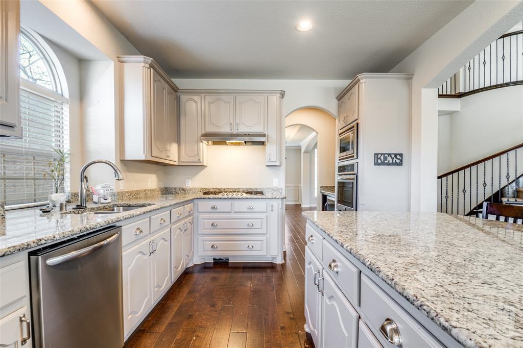 679 Princeton Way Rockwall, TX 75087 - Photo 6 of 25 a kitchen with granite countertop a sink stove and cabinets