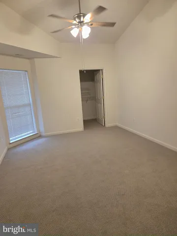 an empty room with a ceiling fan and a window