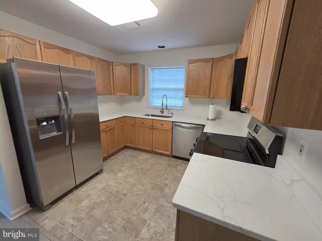 a kitchen with stainless steel appliances a refrigerator sink and cabinets