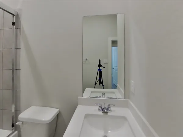 a bathroom with a sink toilet and mirror
