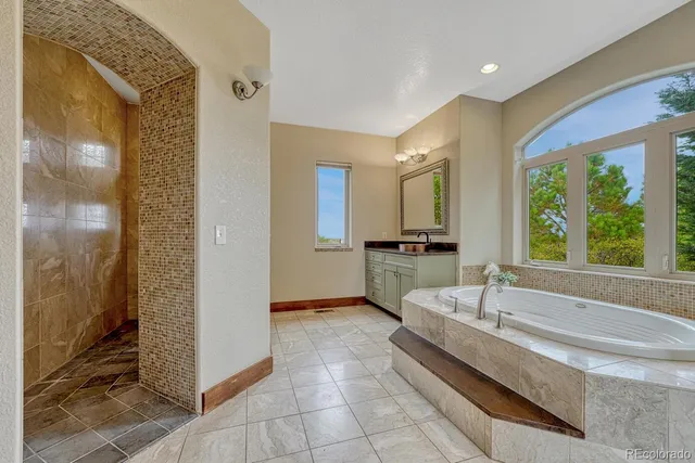 a spacious bathroom with a tub and mirror