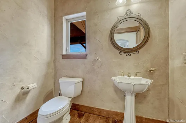 a bathroom with a toilet sink and mirror