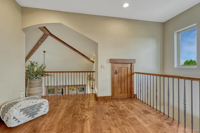 a view of a hallway with wooden floor and stairs