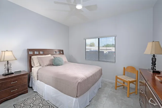 a bedroom with bed and window with chair