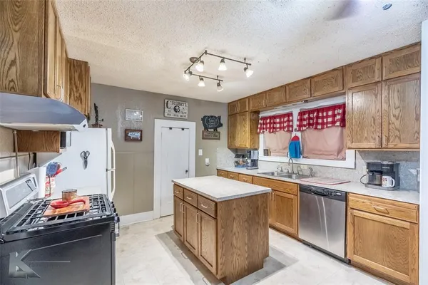 a kitchen with stainless steel appliances granite countertop a sink and cabinets