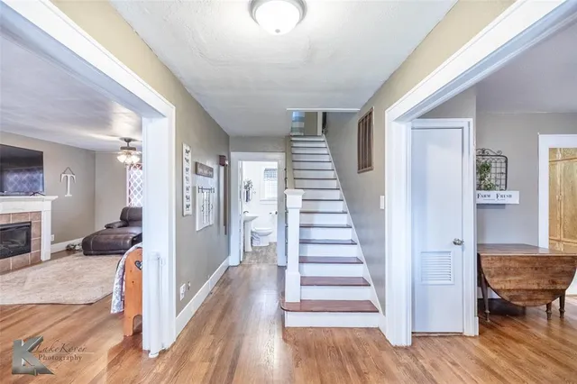 a view of a livingroom with wooden floor and a fireplace