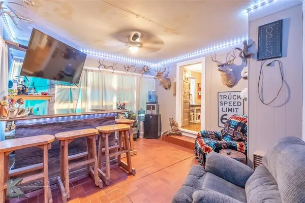 a living room with furniture a flat screen tv and a large window