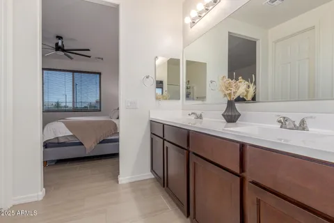 an empty room with wooden floor chandelier fan and windows