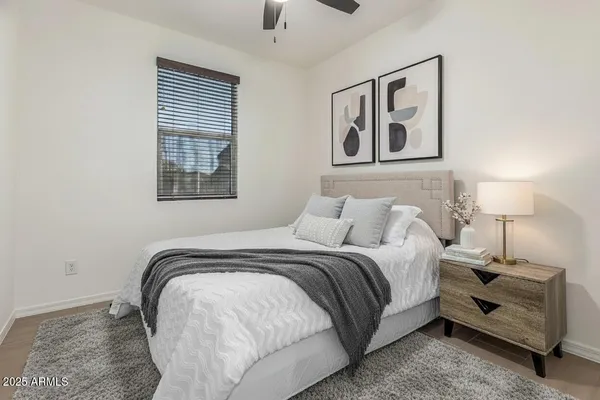 a bed sitting in a bedroom next to a window and a chandelier
