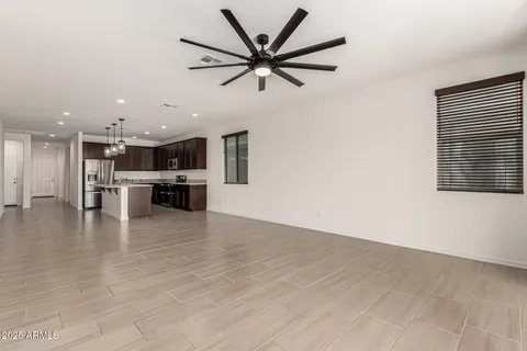 a kitchen with stainless steel appliances a stove a sink a refrigerator and chairs
