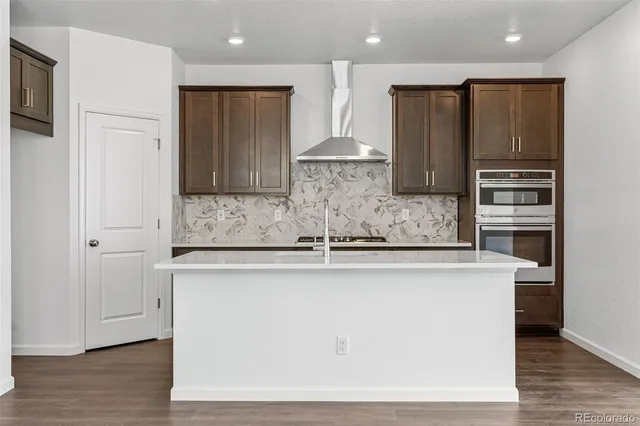 a kitchen with stainless steel appliances granite countertop a sink and a refrigerator
