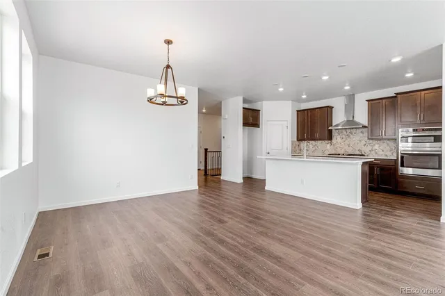 a view of a kitchen with granite countertop stainless steel appliances and wooden floor