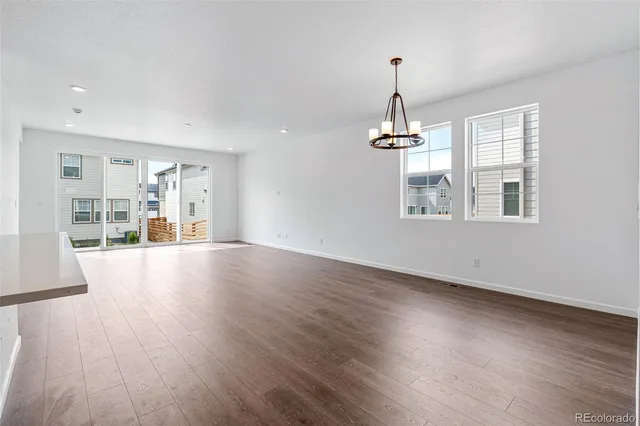 a view of a hallway with wooden floor and windows