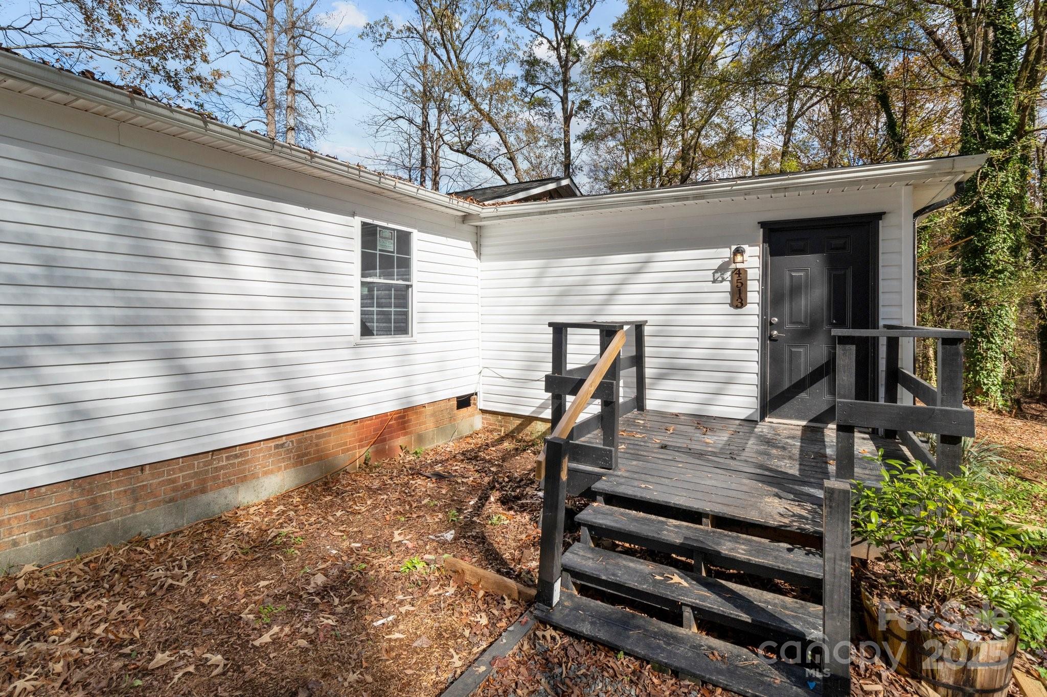 4642 McClure Road Charlotte, NC 28216 - Photo 14 of 48 a backyard of a house with wooden fence and large trees