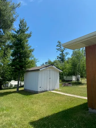 a backyard of a house with plants and large tree