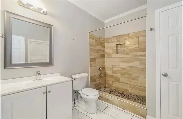 a bathroom with a toilet a sink a shower and a mirror