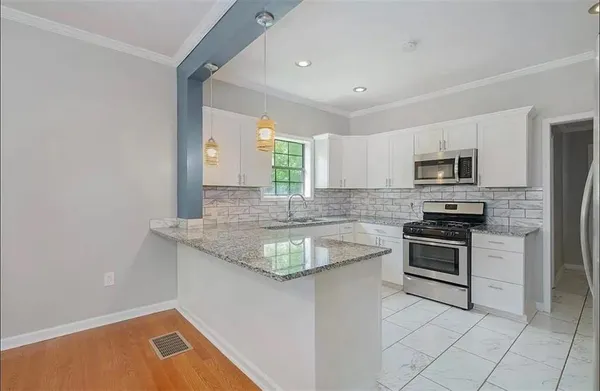 a kitchen with granite countertop a sink and stainless steel appliances