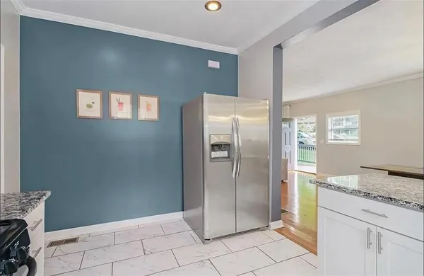 a bathroom with a granite countertop sink and a refrigerator