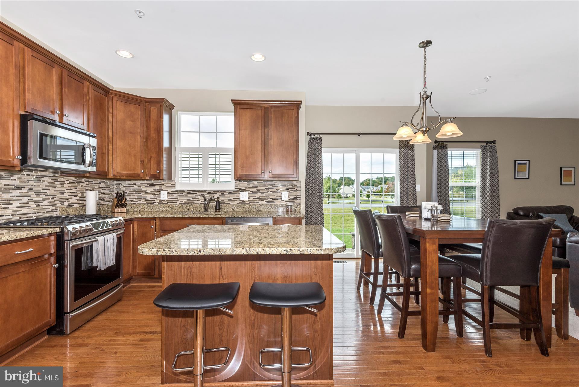 4000 Paw Paw Circle Point of Rocks, MD 21777 - Photo 13 of 30 a kitchen with stainless steel appliances granite countertop wooden floor dining table and chairs