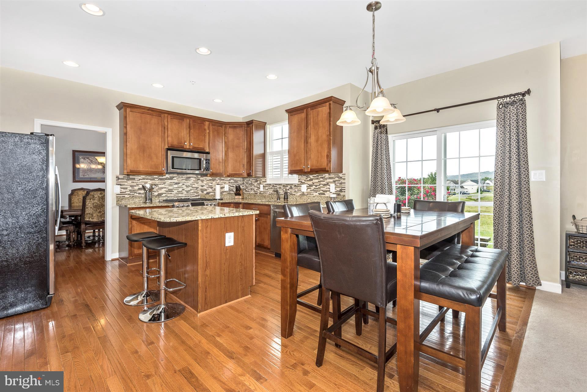 4000 Paw Paw Circle Point of Rocks, MD 21777 - Photo 10 of 30 a kitchen with stainless steel appliances granite countertop dining table chairs and wooden floor