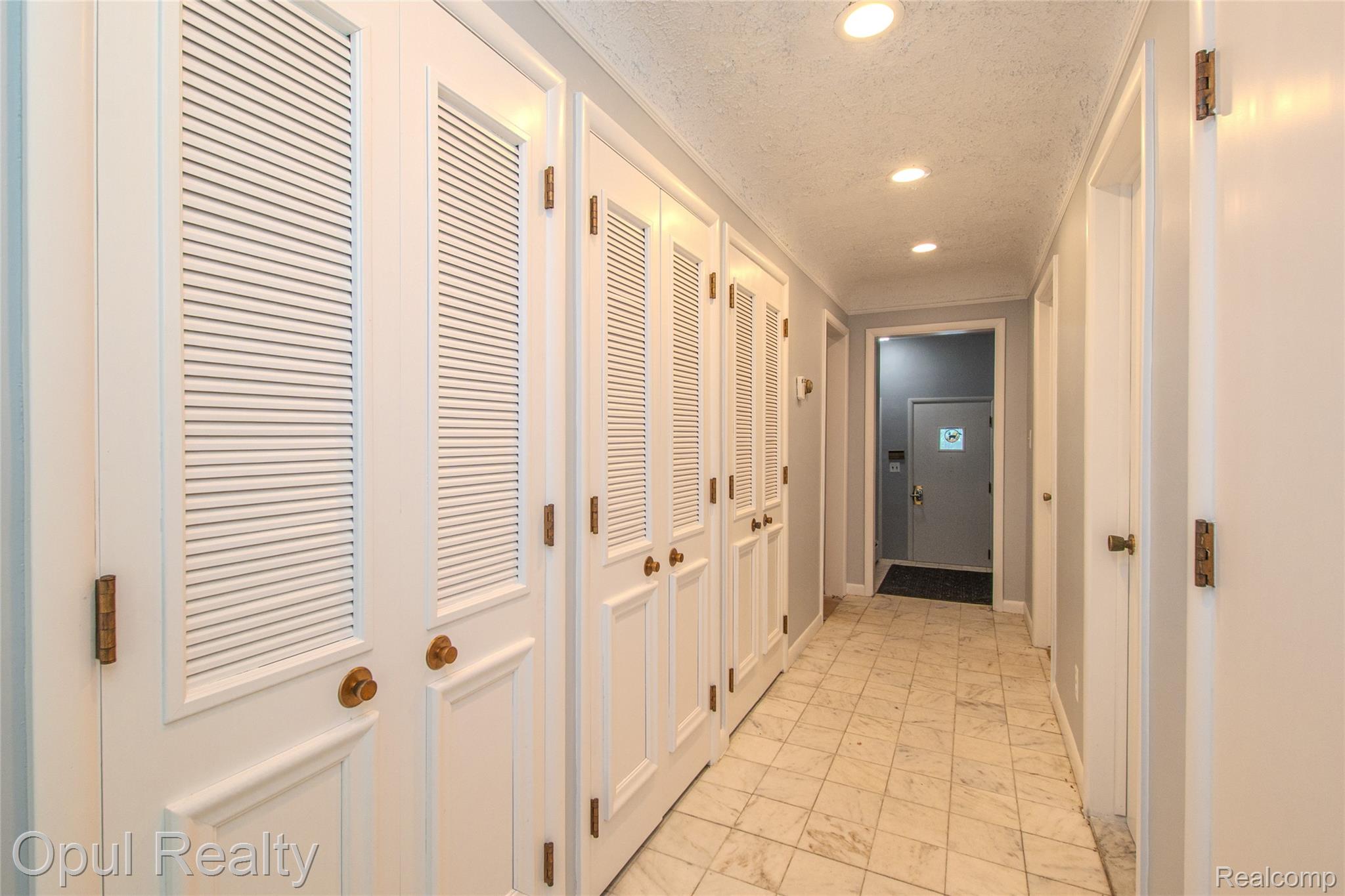 6455 Norham Road Bloomfield Hills, MI 48301 - Photo 25 of 93 Hallway featuring extensive louvered closet doors, recessed lighting, and tile flooring