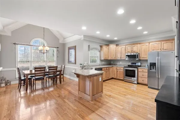 a kitchen with kitchen island wooden cabinets and stainless steel appliances