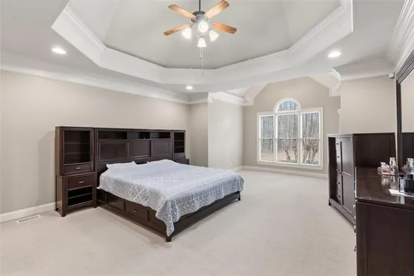 a spacious bedroom with a bed and a large window