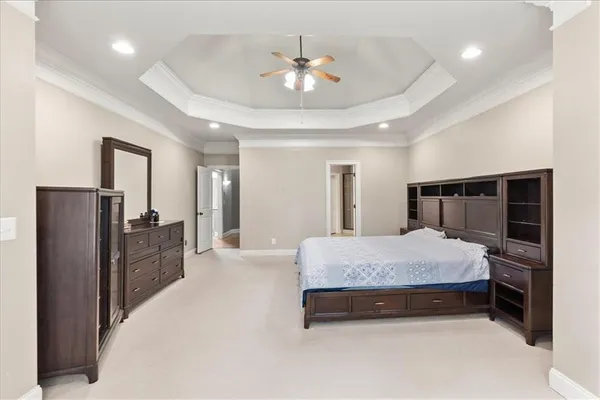 a spacious bedroom with a bed and a chandelier