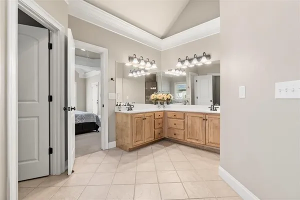 a large white room with a large mirror and cabinets
