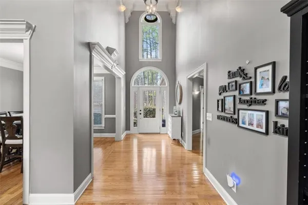 a view of a hallway with wooden floor and a living room