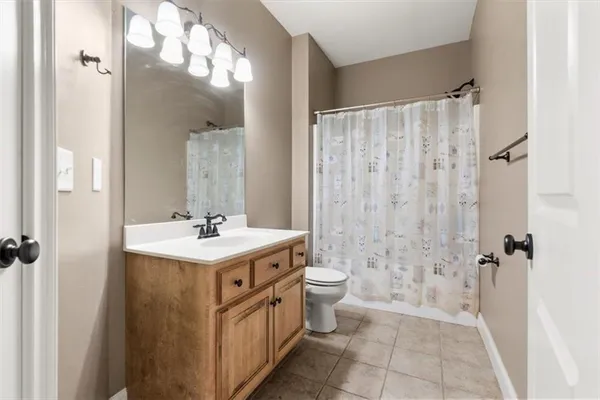 a bathroom with a sink a toilet a mirror and shower