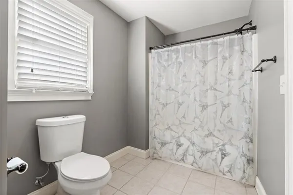 a white toilet sitting next to a shower curtain