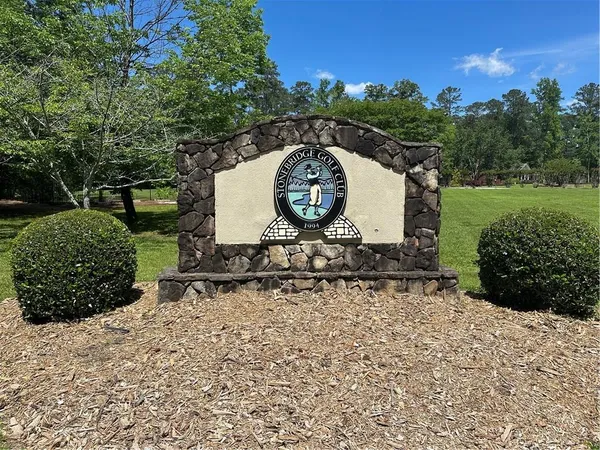 a green field with lots of trees in the background
