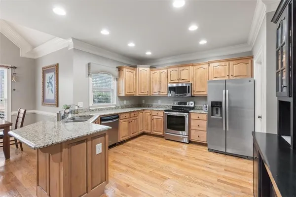 a kitchen with stainless steel appliances granite countertop a sink stove refrigerator and cabinets
