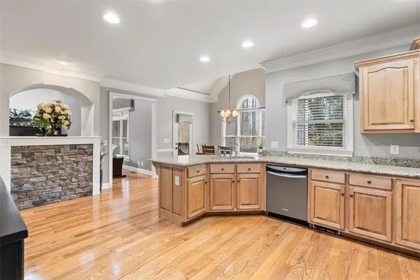 a large kitchen with granite countertop a sink and cabinets