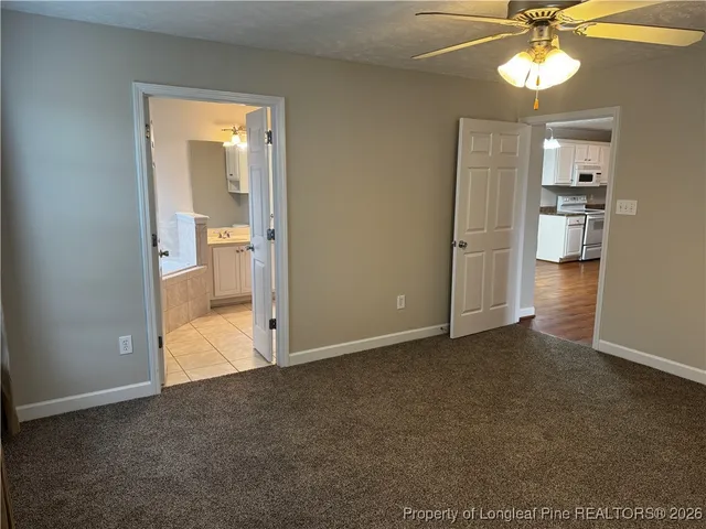 an empty room with fan and a bathroom