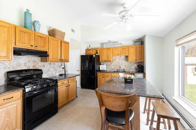 a kitchen with stainless steel appliances granite countertop a stove a sink and a refrigerator