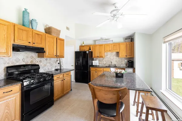 a kitchen with stainless steel appliances granite countertop a stove a sink and a refrigerator