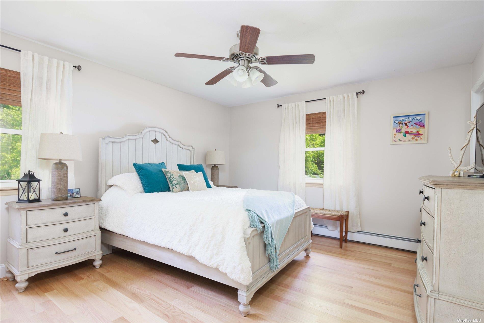 400 Wells Road Laurel, NY 11948 - Photo 7 of 17 a bedroom with a bed and a chandelier