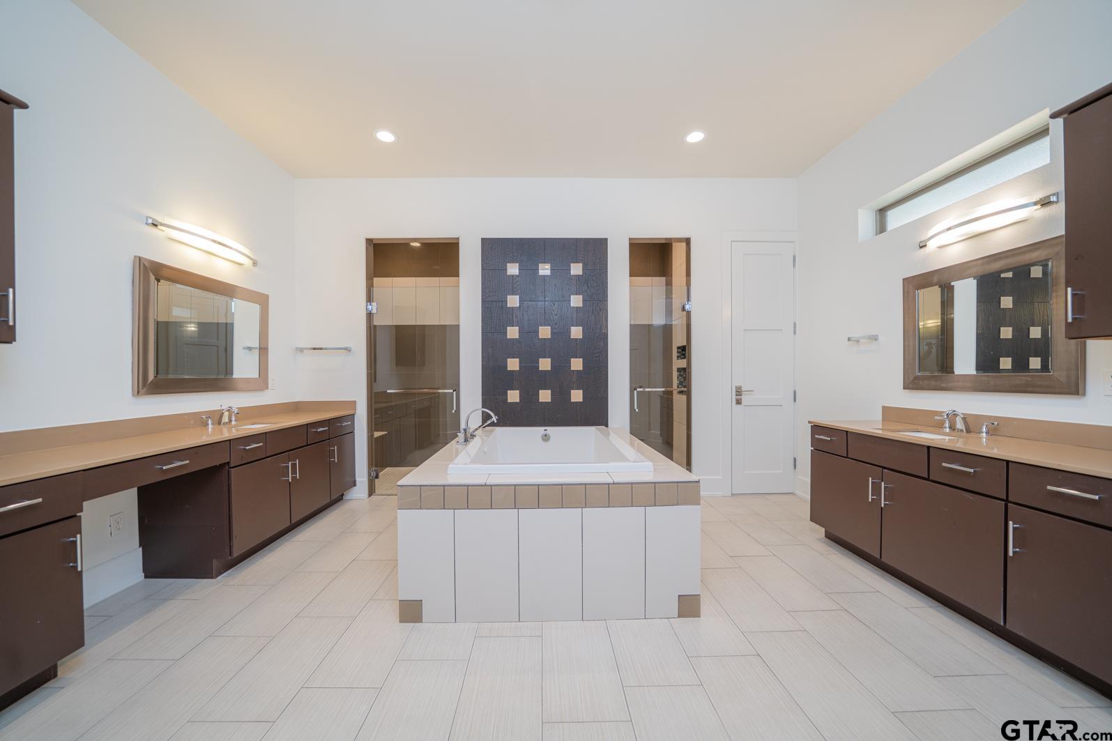 8 Stonebridge Court Longview, TX 75605 - Photo 23 of 48 a spacious bathroom with a granite countertop tub sink shower and mirror