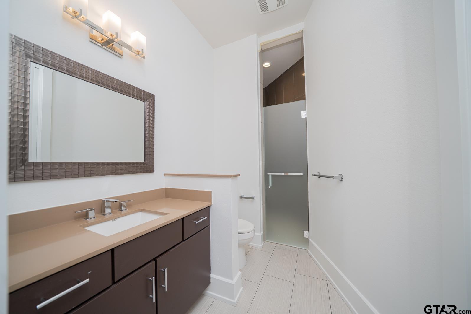 8 Stonebridge Court Longview, TX 75605 - Photo 37 of 48 a bathroom with a sink vanity and a mirror