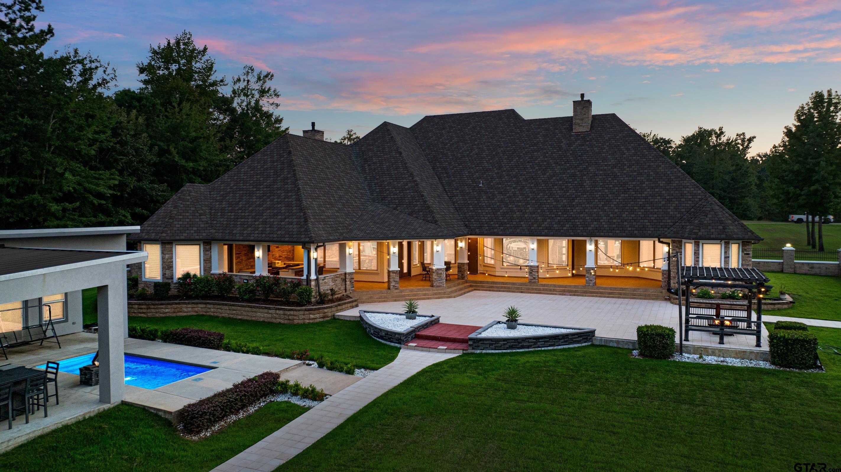 8 Stonebridge Court Longview, TX 75605 - Photo 4 of 48 a view of a swimming pool with lawn chairs under an umbrella