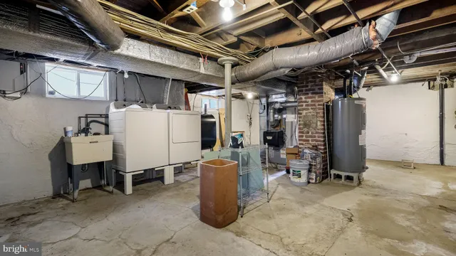 a view of a storage room with water heater and chairs