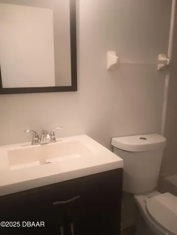 a bathroom with a sink a toilet and mirror