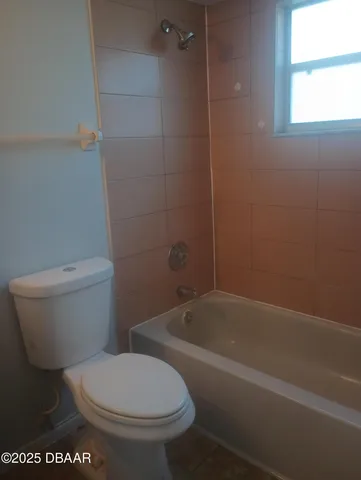a white toilet sitting next to a bath tub