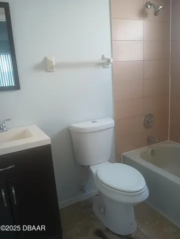 a white toilet sitting next to a bath tub
